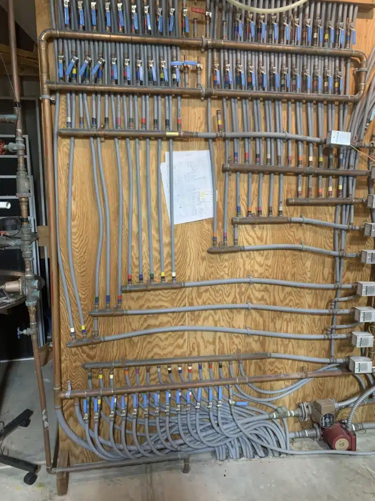 Before image of a failing polybutylene hydronic radiant heat piping system.